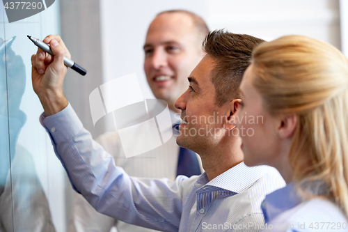 Image of business team with marker writing on glass board