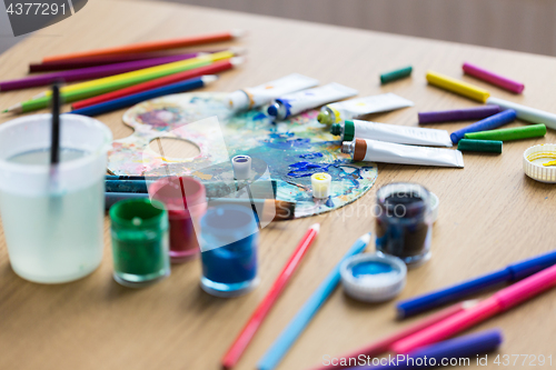 Image of palette, brushes and paint tubes on table