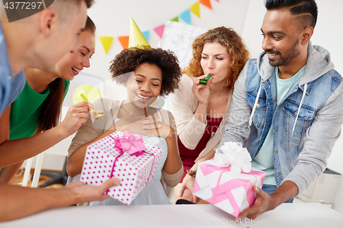 Image of team greeting colleague at office birthday party