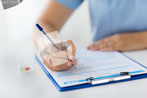 Image of doctor with medicines and clipboard at hospital