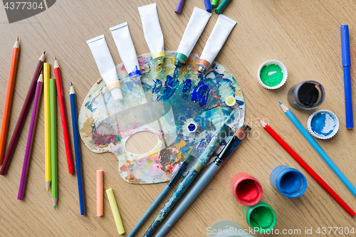 Image of color palette, brushes and paint tubes on table