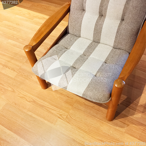 Image of Comfortable striped armchair on a wooden floor