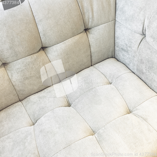 Image of Corner of a shiny white velvet sofa