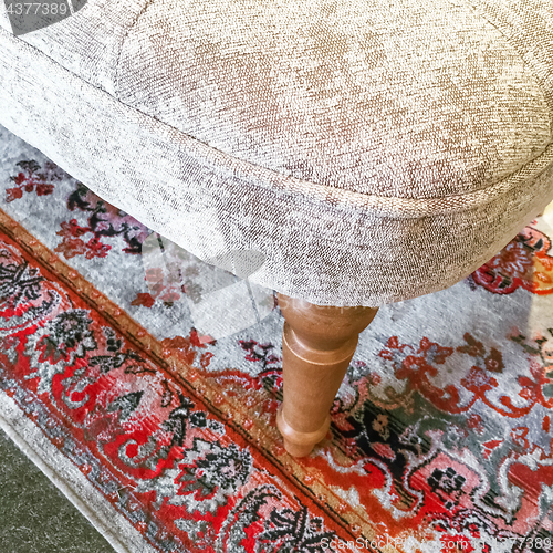 Image of Detail of a luxurious armchair on a classic rug