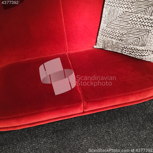 Image of Red velvet sofa with gray ornamental cushion