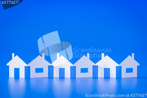 Image of a paper cutout row of houses blue background