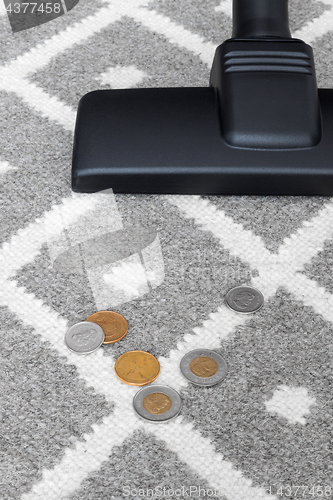 Image of Vacuum cleaner and coins on gray carpet