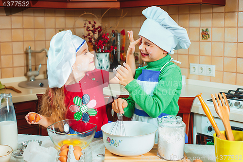 Image of happy family funny kids are preparing the dough, bake cookies in the kitchen