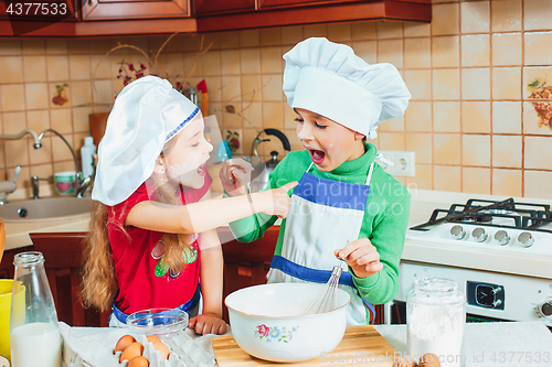 Image of happy family funny kids are preparing the dough, bake cookies in the kitchen