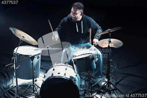 Image of Drummer rehearsing on drums before rock concert. Man recording music on drum set in studio