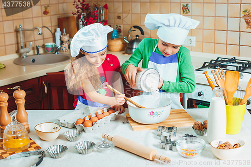 Image of happy family funny kids are preparing the dough, bake cookies in the kitchen