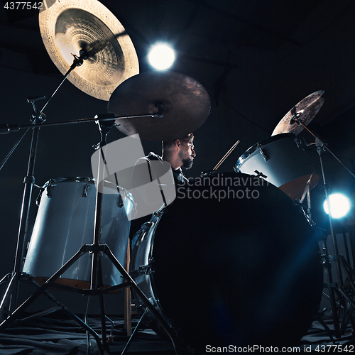 Image of Drummer rehearsing on drums before rock concert. Man recording music on drum set in studio