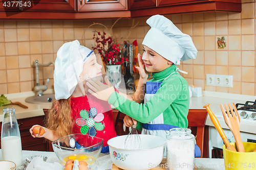 Image of happy family funny kids are preparing the dough, bake cookies in the kitchen