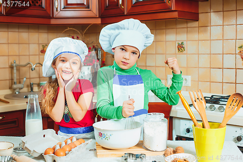 Image of happy family funny kids are preparing the dough, bake cookies in the kitchen