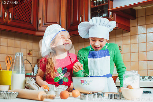 Image of happy family funny kids are preparing the dough, bake cookies in the kitchen