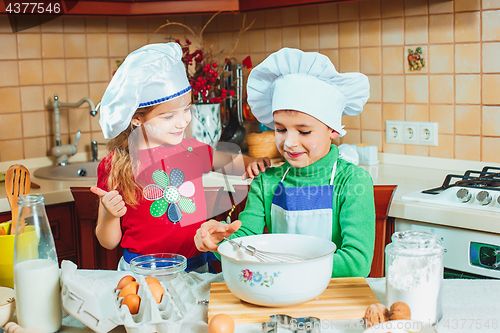 Image of happy family funny kids are preparing the dough, bake cookies in the kitchen