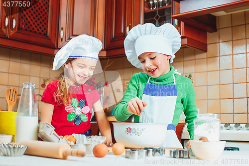 Image of happy family funny kids are preparing the dough, bake cookies in the kitchen