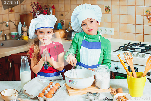 Image of happy family funny kids are preparing the dough, bake cookies in the kitchen