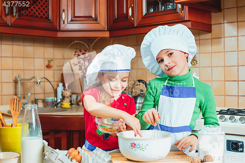 Image of happy family funny kids are preparing the dough, bake cookies in the kitchen