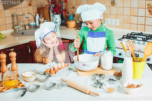 Image of happy family funny kids are preparing the dough, bake cookies in the kitchen