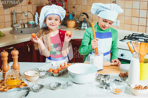 Image of happy family funny kids are preparing the dough, bake cookies in the kitchen