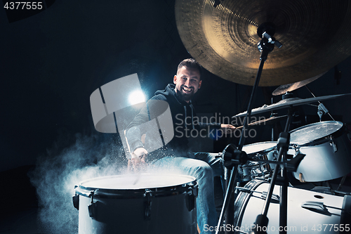 Image of Drummer rehearsing on drums before rock concert. Man recording music on drum set in studio