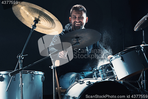 Image of Drummer rehearsing on drums before rock concert. Man recording music on drum set in studio