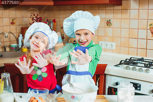 Image of happy family funny kids are preparing the dough, bake cookies in the kitchen