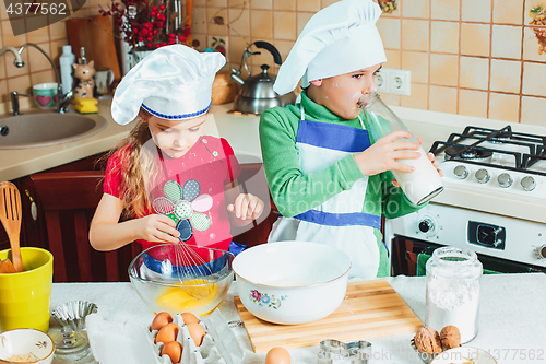 Image of happy family funny kids are preparing the dough, bake cookies in the kitchen