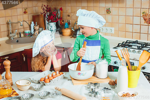 Image of happy family funny kids are preparing the dough, bake cookies in the kitchen