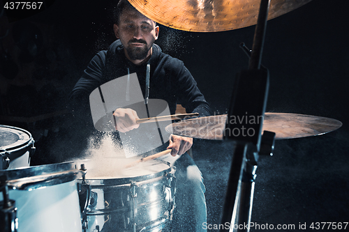 Image of Drummer rehearsing on drums before rock concert. Man recording music on drum set in studio