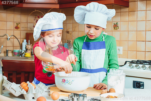 Image of happy family funny kids are preparing the dough, bake cookies in the kitchen