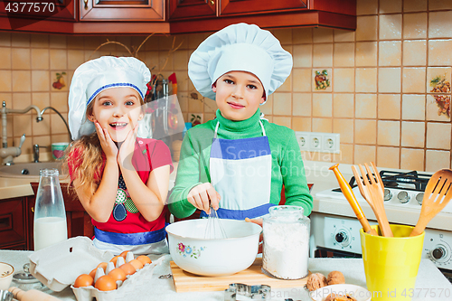 Image of happy family funny kids are preparing the dough, bake cookies in the kitchen