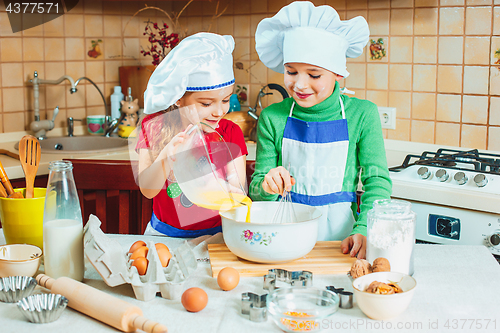 Image of happy family funny kids are preparing the dough, bake cookies in the kitchen