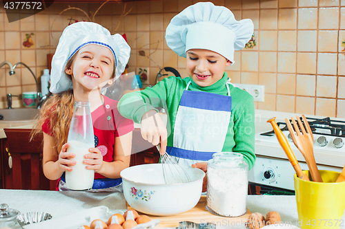 Image of happy family funny kids are preparing the dough, bake cookies in the kitchen