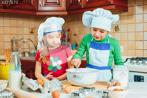 Image of happy family funny kids are preparing the dough, bake cookies in the kitchen