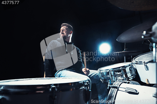 Image of Drummer rehearsing on drums before rock concert. Man recording music on drum set in studio