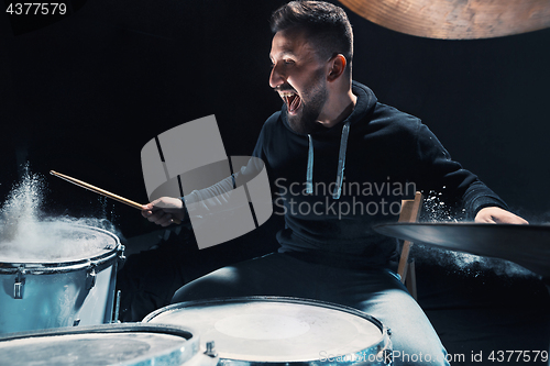 Image of Drummer rehearsing on drums before rock concert. Man recording music on drum set in studio