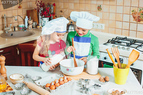 Image of happy family funny kids are preparing the dough, bake cookies in the kitchen