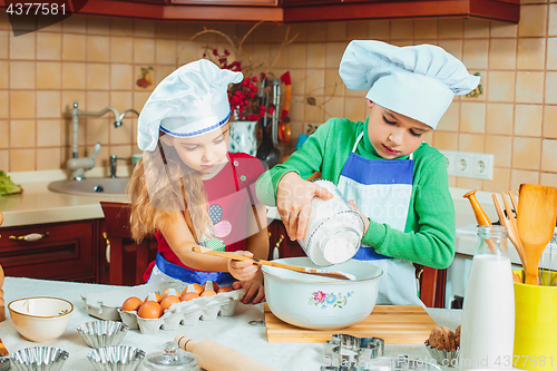 Image of happy family funny kids are preparing the dough, bake cookies in the kitchen