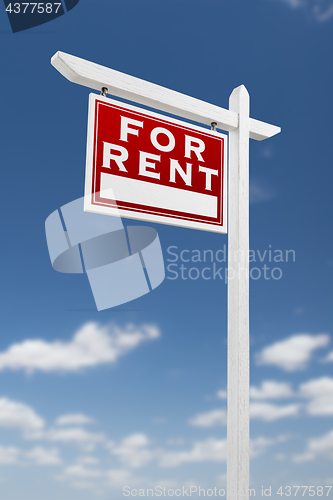 Image of Left Facing For Rent Real Estate Sign on a Blue Sky with Clouds.