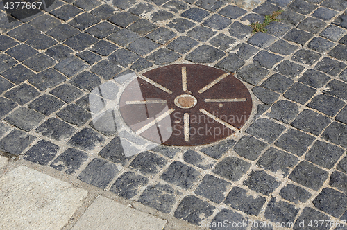 Image of Cobblestones pavement with metal round detail