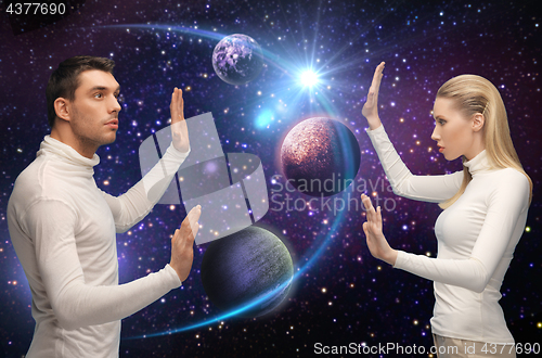 Image of futuristic couple over planet and stars in space