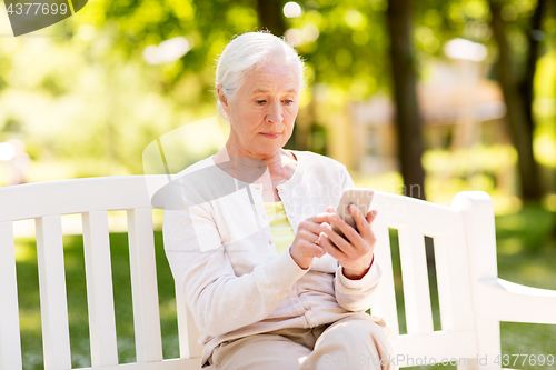 Image of senior woman with smartphone at summer park