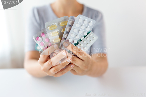 Image of woman hands holding packs of pills