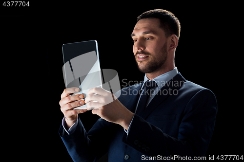 Image of businessman in suit with transparent tablet pc