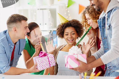 Image of team greeting colleague at office birthday party