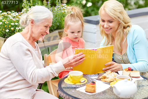 Image of happy family reading book at cafe