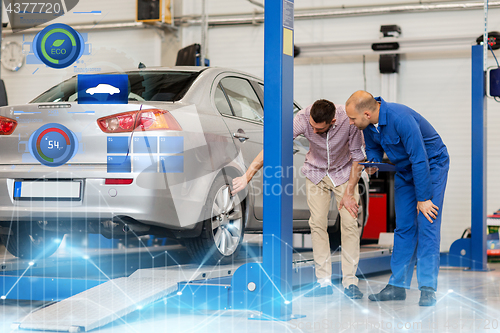 Image of auto mechanic with clipboard and man at car shop