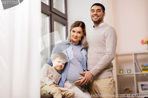 Image of happy family with pregnant mother at home